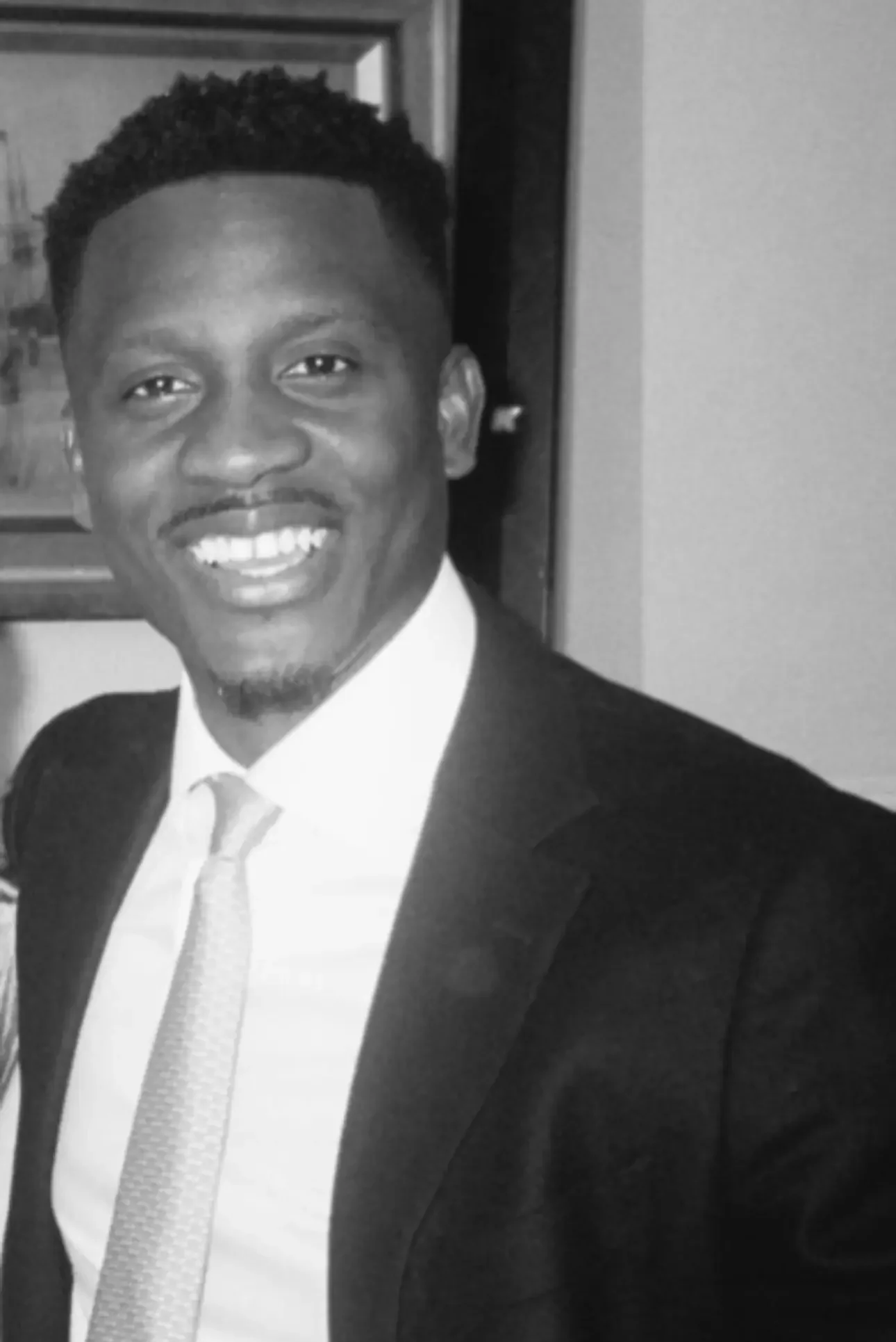 Smiling man in suit and tie posing for professional portrait.